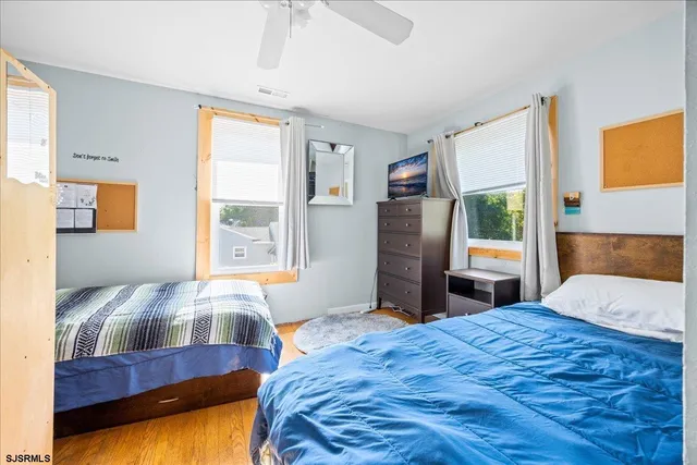 a bedroom with a bed and a dresser next to a window