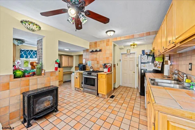 a kitchen with stainless steel appliances kitchen island granite countertop a stove a sink and a refrigerator
