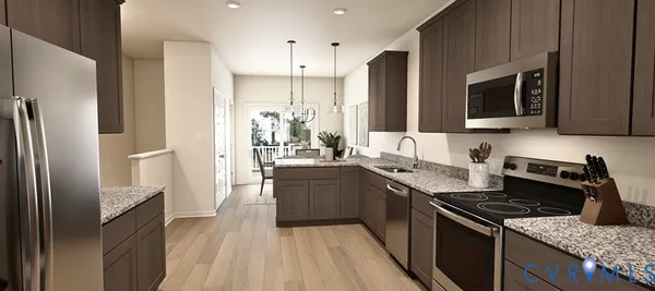 a kitchen with stainless steel appliances granite countertop a stove refrigerator sink and microwave