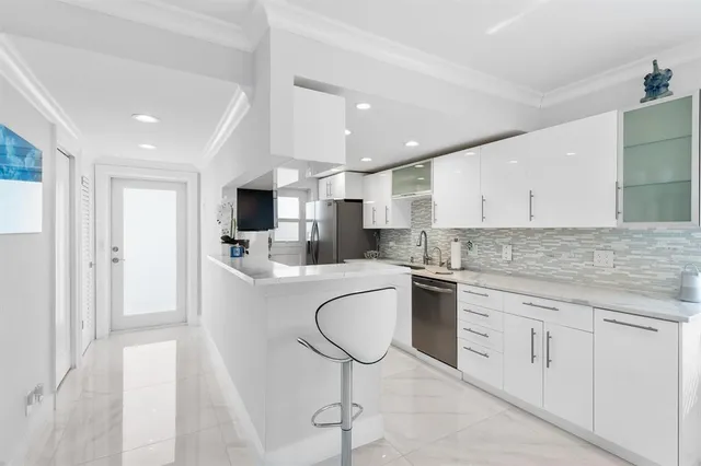 a kitchen with granite countertop a sink stainless steel appliances and white cabinets