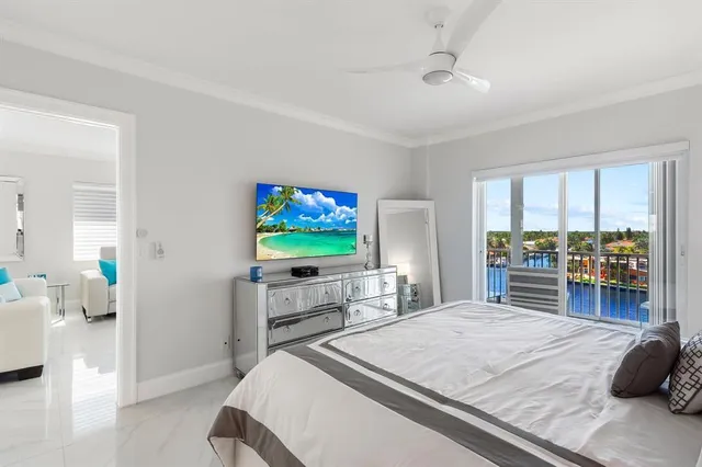a bedroom with a bed and a flat tv screen on dresser