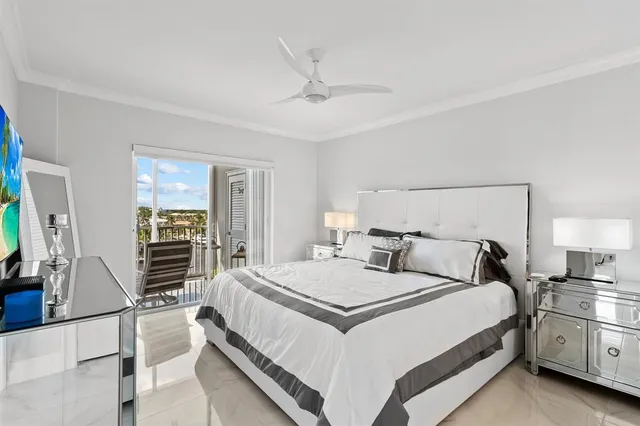 a bedroom with a bed and a flat tv screen on dresser