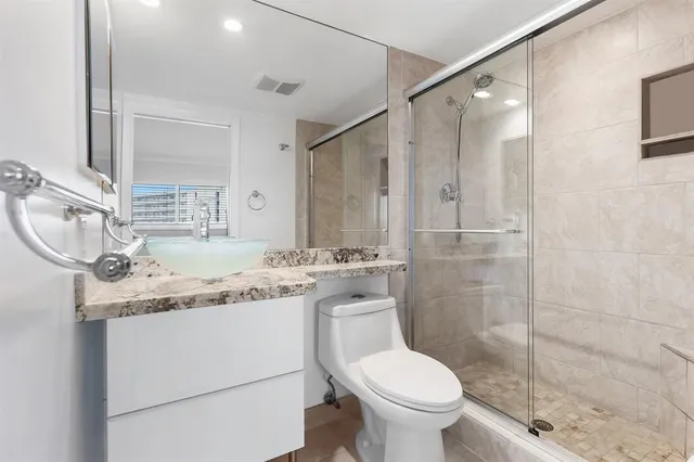 a bathroom with a granite countertop sink toilet and shower
