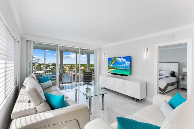 a living room with furniture a flat screen tv and a large window