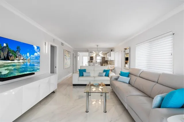 a living room with furniture and a open kitchen view
