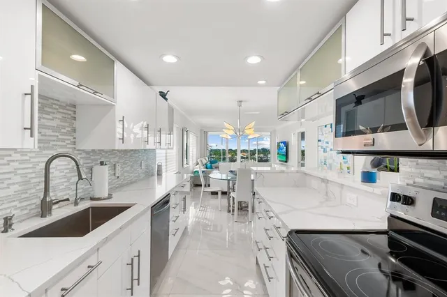 a large kitchen with stainless steel appliances lots of counter space and a sink