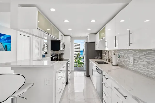 a large kitchen with stainless steel appliances lots of counter space sink and a window