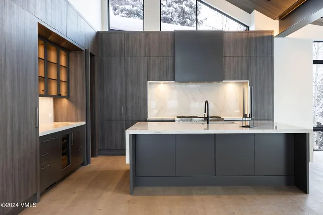 a front view of a house with yard and trees in the background