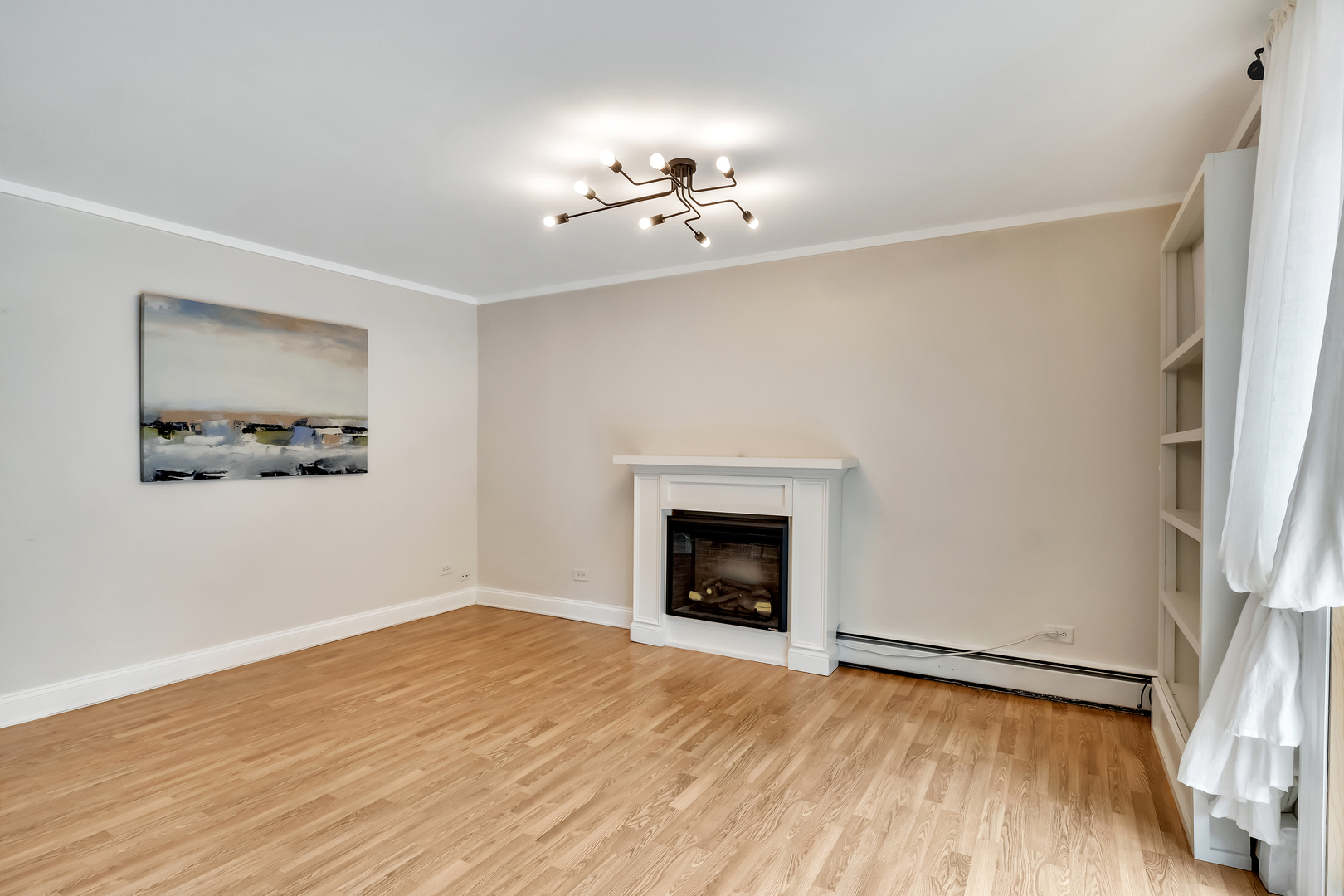 1341 Greenwillow Lane, Unit A Glenview, IL 60025 - Photo 6 of 27 a view of an empty room with wooden floor fireplace and a window