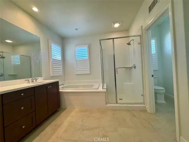 a spacious bathroom with a mirror a shower and a sink