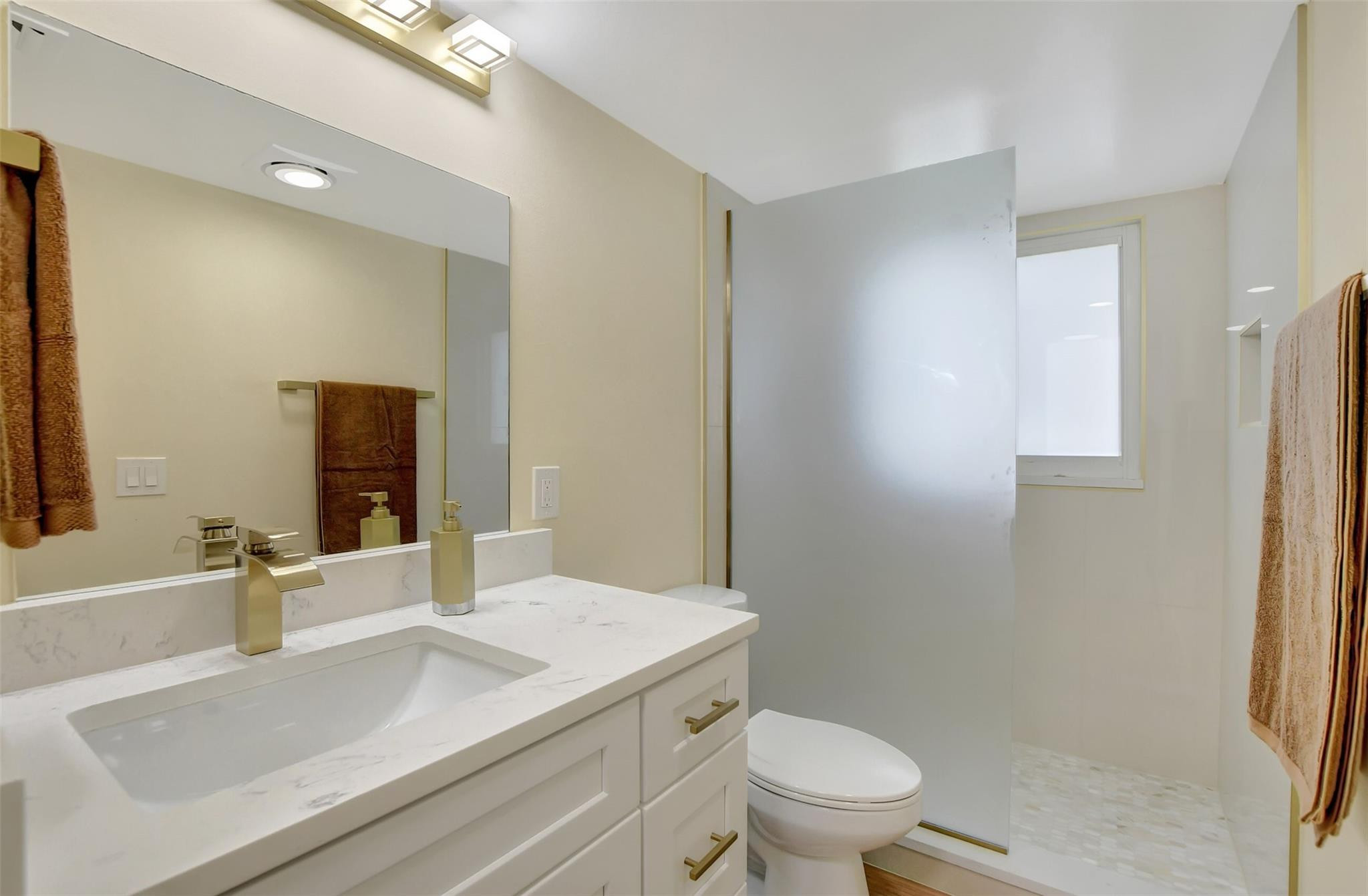 1019 Guildford East, Unit 1019 Boca Raton, FL 33434 - Photo 26 of 38 a bathroom with a sink toilet vanity and shower
