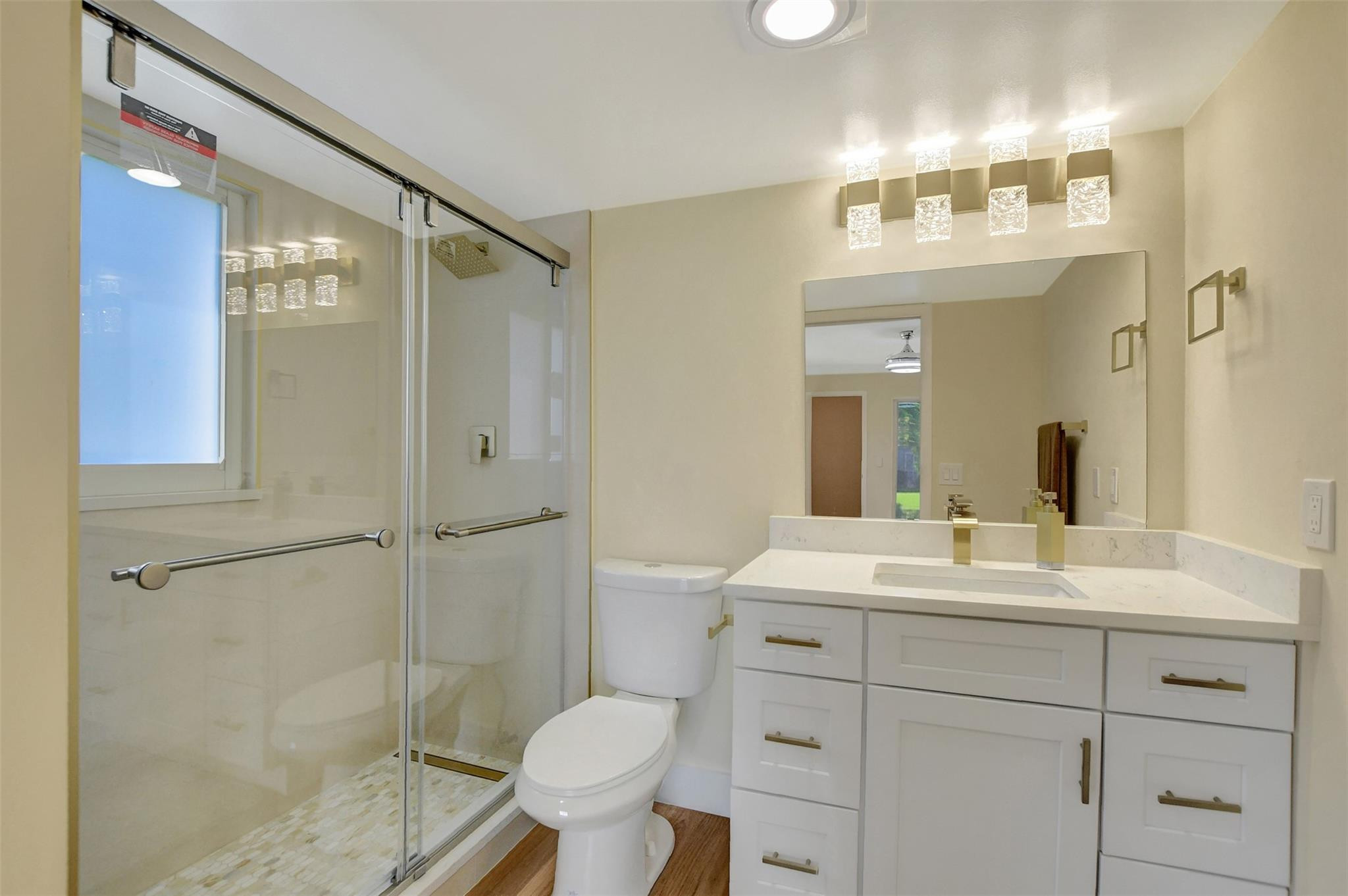 1019 Guildford East, Unit 1019 Boca Raton, FL 33434 - Photo 30 of 38 a bathroom with a sink toilet a mirror and shower