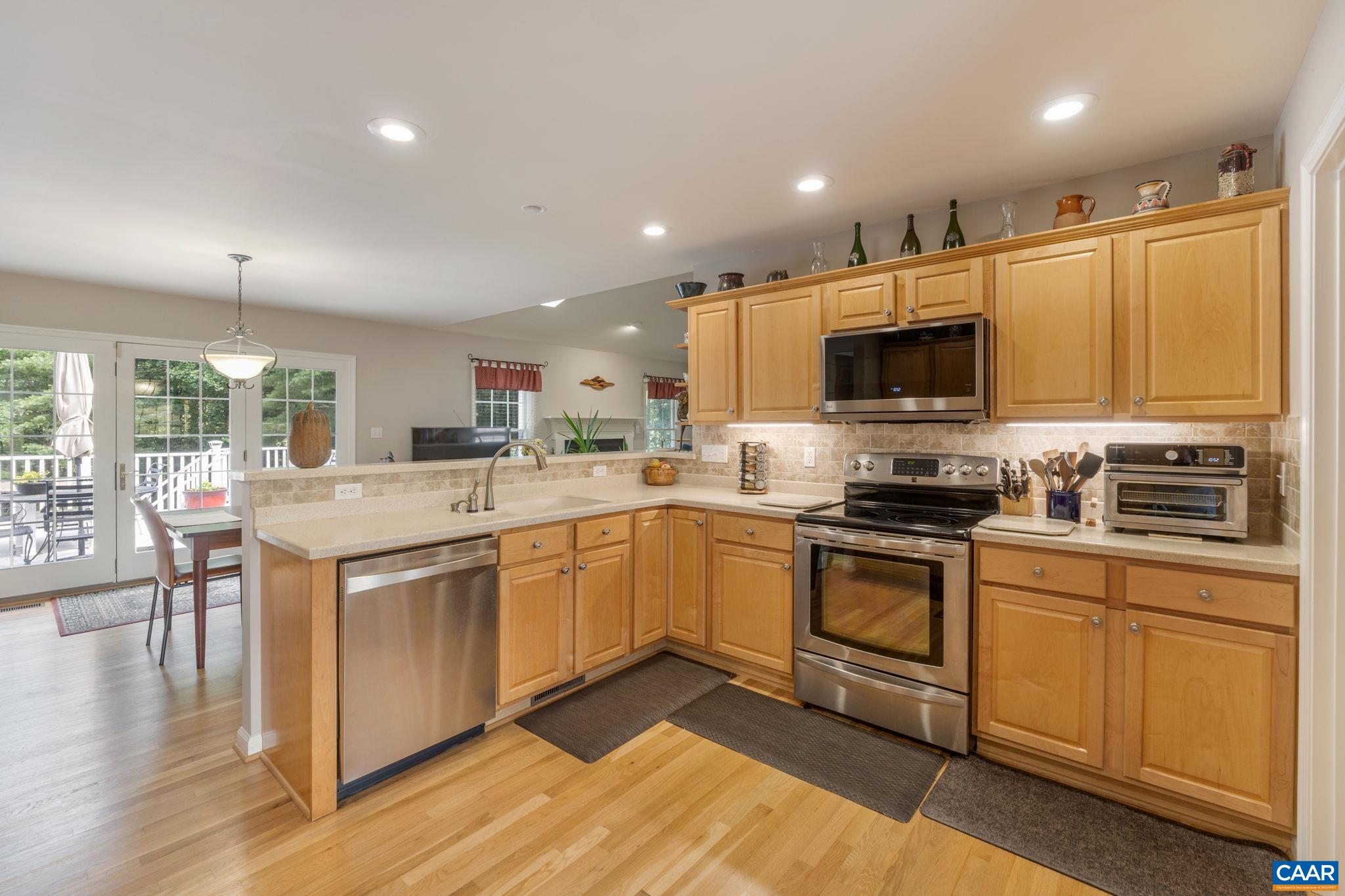 1900 Fray Road Advance Mills, VA 22968 - Photo 23 of 59 a kitchen with stainless steel appliances kitchen island granite countertop a stove top oven a sink a dining table and chairs