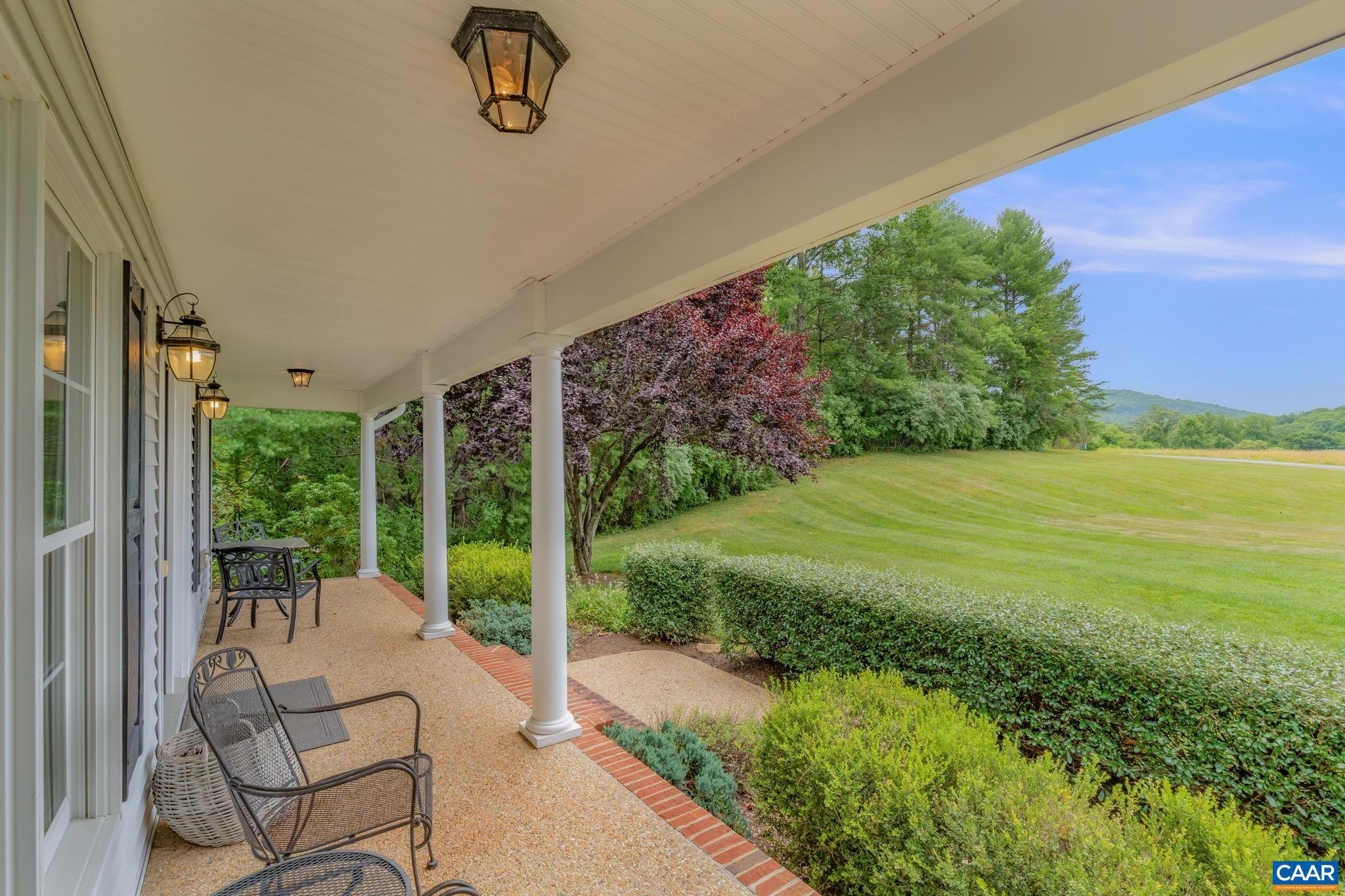 1900 Fray Road Advance Mills, VA 22968 - Photo 10 of 59 a view of a patio with lawn chairs floor to ceiling window and garden