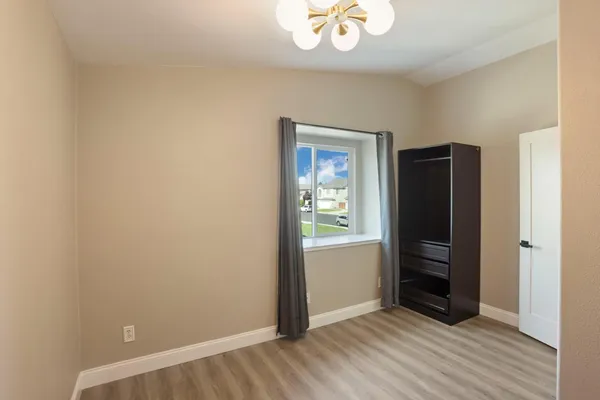 a bedroom with a bed dresser and a window