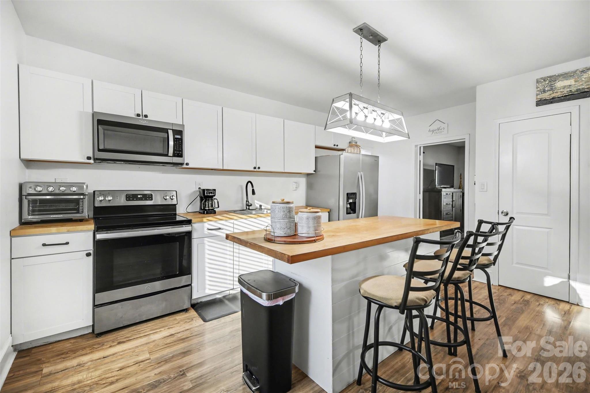 918 8th Street Lancaster, SC 29720 - Photo 4 of 32 a kitchen with stainless steel appliances a stove a sink dishwasher a microwave oven with a dining table and chairs