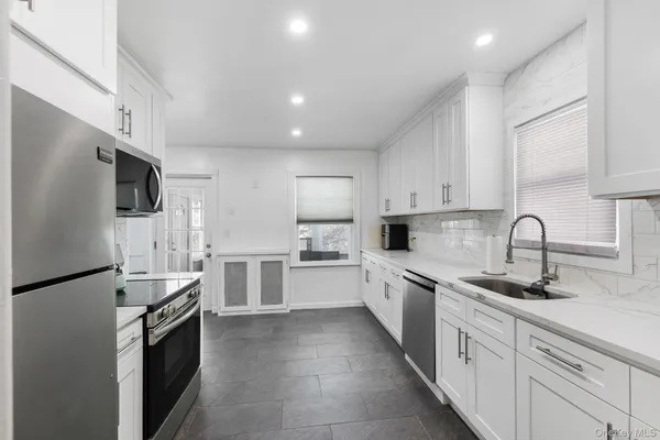 a kitchen with white cabinets and stainless steel appliances