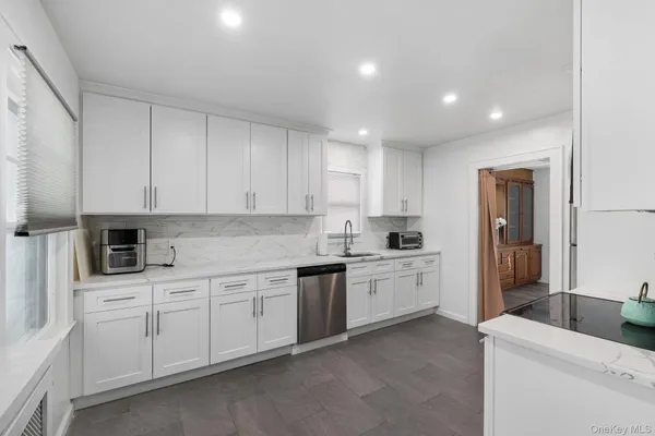 a kitchen with white cabinets and sink