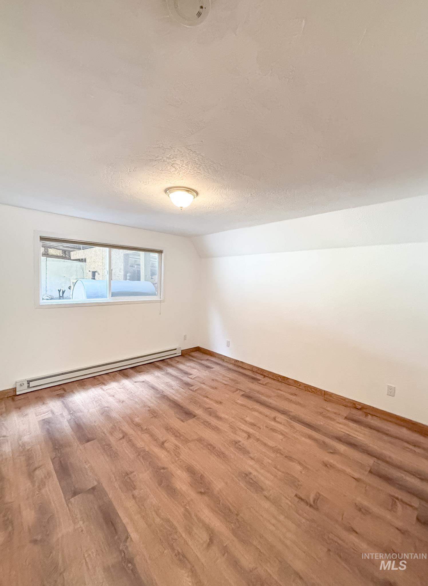 302 Rossiter Court Pierce, ID 83546 - Photo 12 of 30 Spacious room featuring wood-finish flooring and white walls
