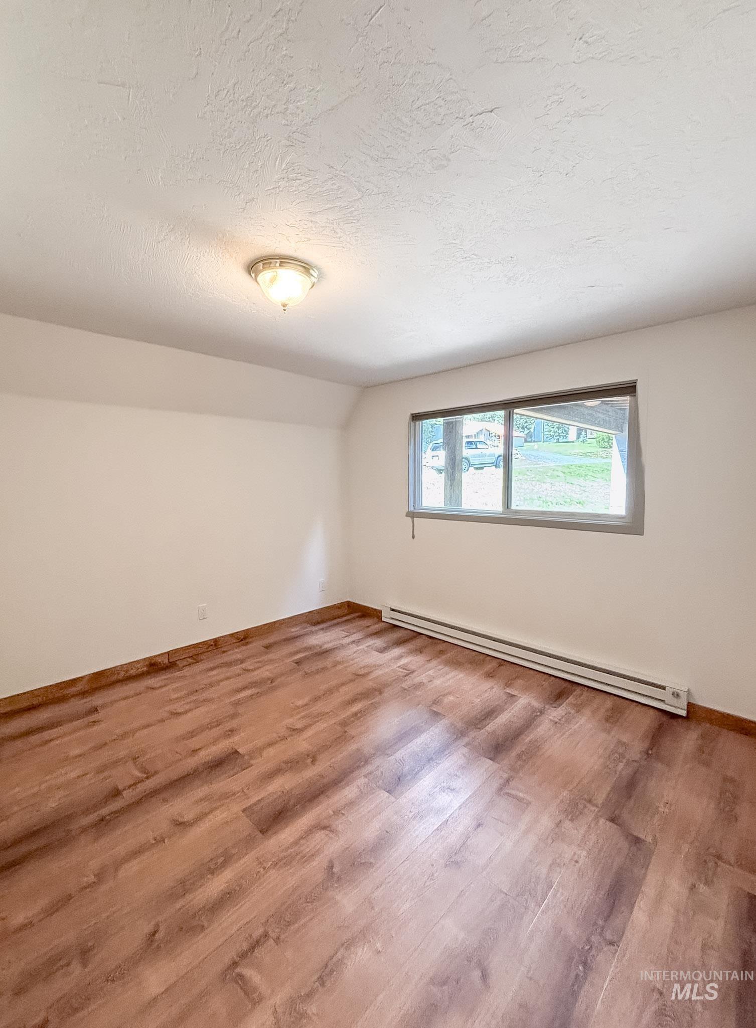 302 Rossiter Court Pierce, ID 83546 - Photo 13 of 30 Room with wood-finish flooring, white walls, and a recessed window