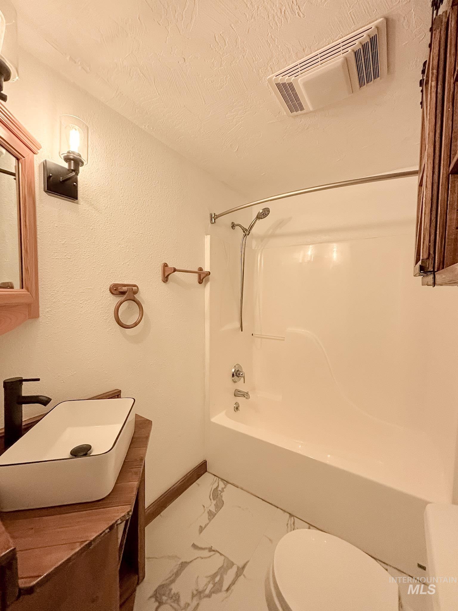 302 Rossiter Court Pierce, ID 83546 - Photo 22 of 30 Bathroom featuring a white rectangular vessel sink, matte black faucet, and wood-finish vanity
