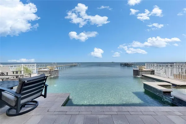 a view of a white house with a small yard and a large tree