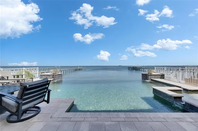 a view of a white house with a small yard and a large tree