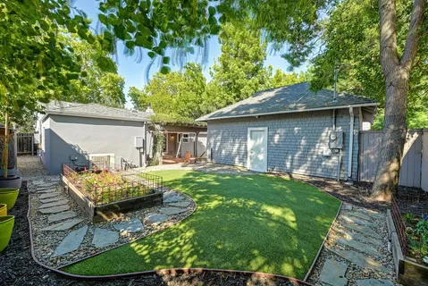 a view of backyard with seating space and trees in the background