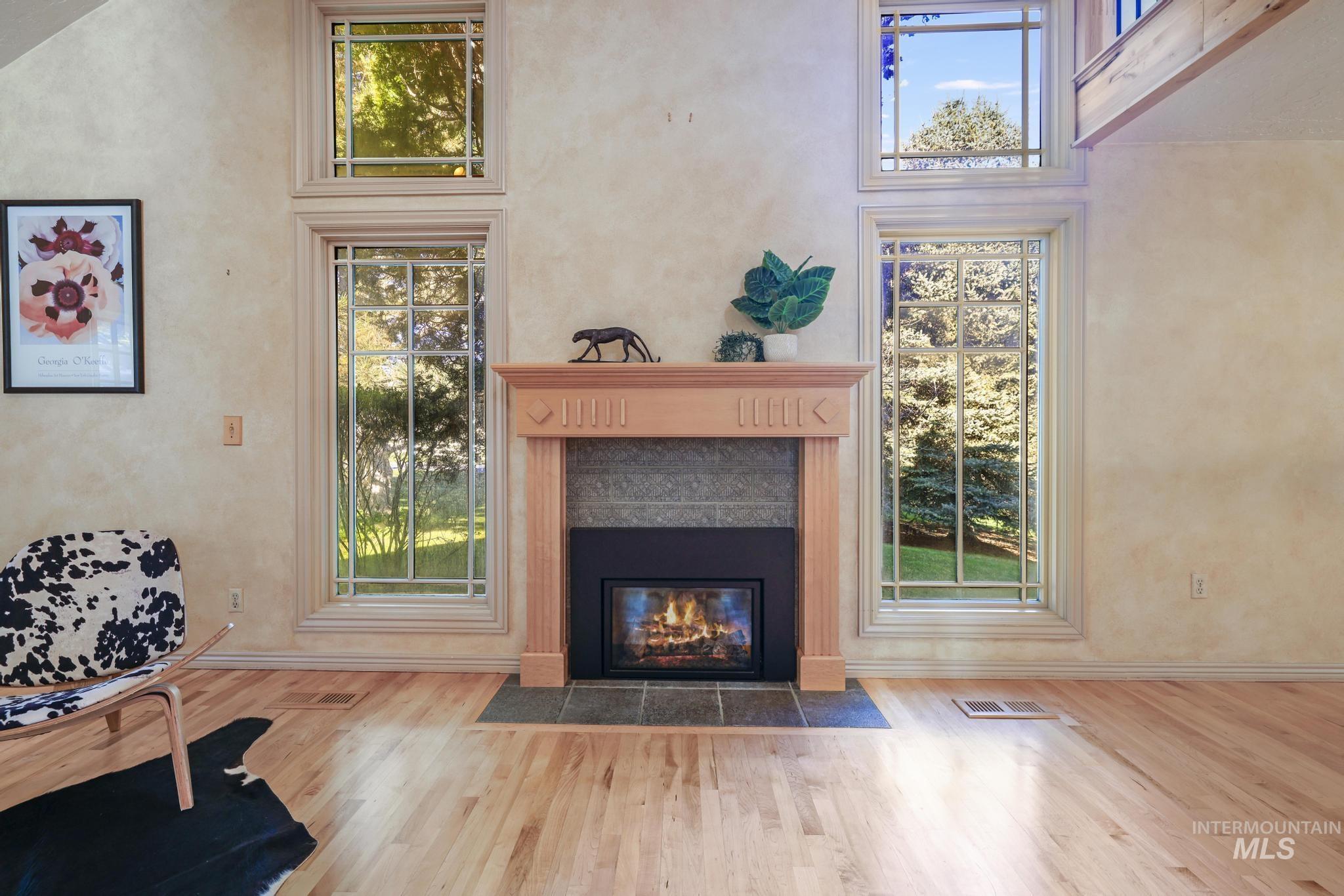 1172 Hankins Road North Twin Falls, ID 83301 - Photo 27 of 49 Living area featuring a high ceiling, light wood-style floors, a tiled fireplace, and healthy amount of natural light