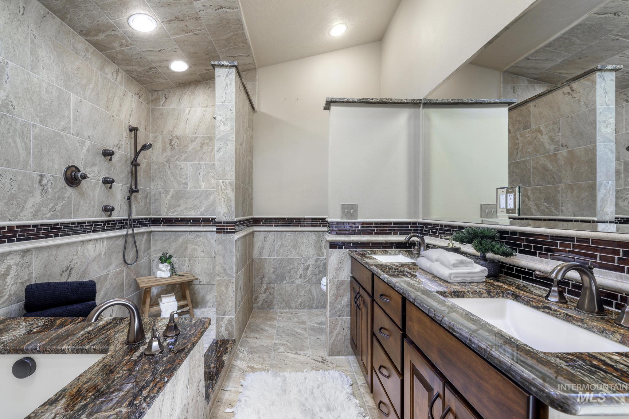1172 Hankins Road North Twin Falls, ID 83301 - Photo 34 of 49 Bathroom with double vanity, tile walls, recessed lighting, a garden tub, and walk in shower