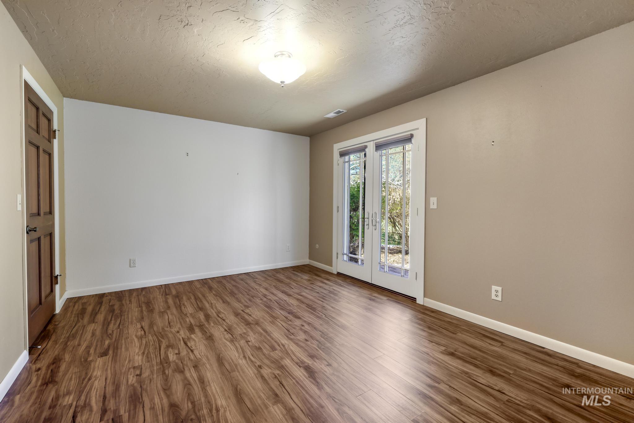 1172 Hankins Road North Twin Falls, ID 83301 - Photo 42 of 49 Empty room with a textured ceiling and dark wood-style flooring