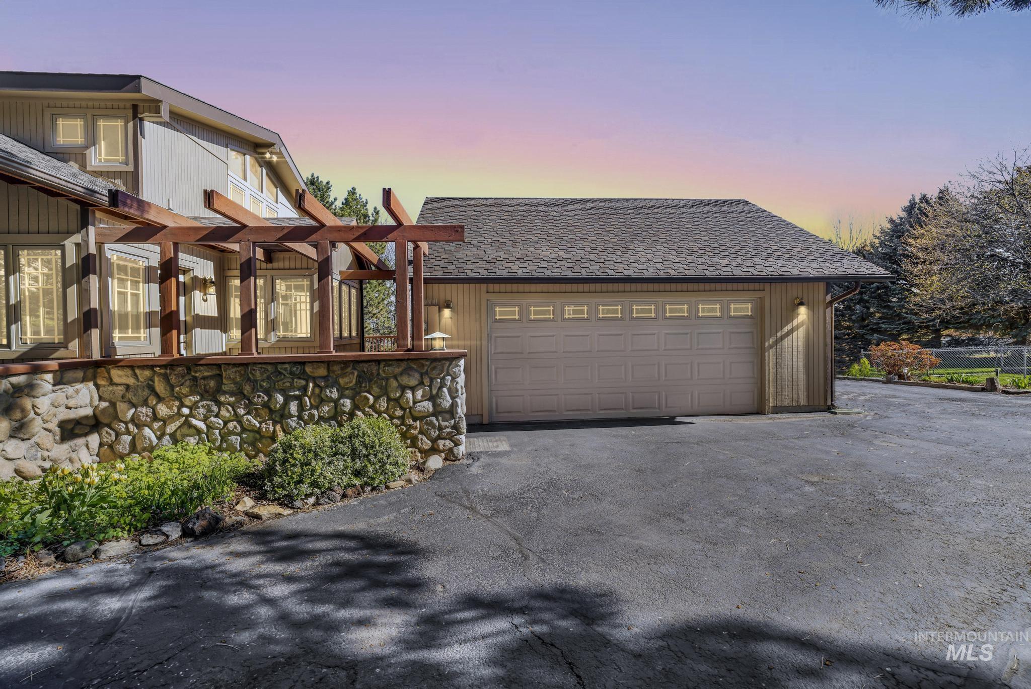 1172 Hankins Road North Twin Falls, ID 83301 - Photo 6 of 49 Property exterior at dusk with asphalt driveway, a shingled roof, and an attached garage