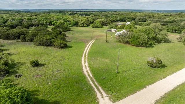 an aerial view of residential houses with outdoor space and trees