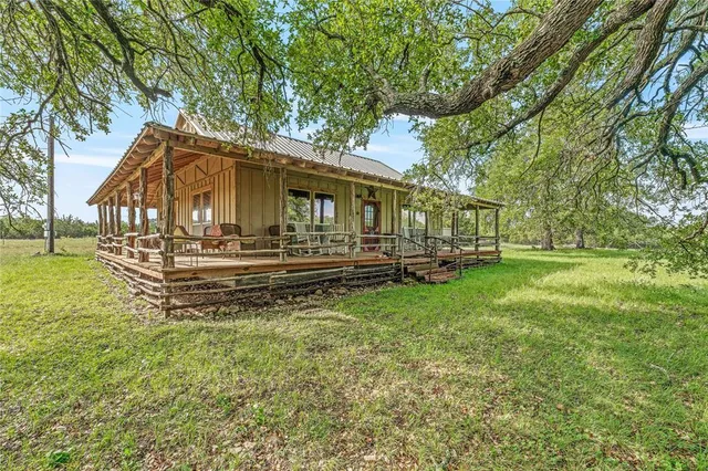a living room with furniture a large window and wooden floor