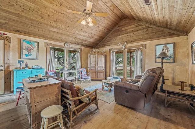 a living room with furniture a large window and wooden floor