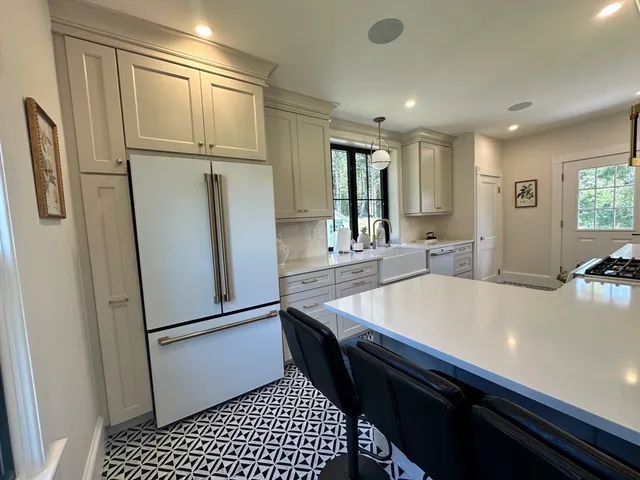 a room with stainless steel appliances furniture a refrigerator and a sink