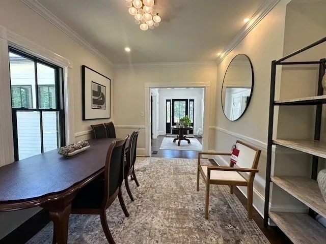a view of a dining room with furniture a chandelier and wooden floor