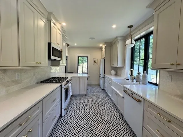 a large kitchen with stainless steel appliances granite countertop a lot of counter space and a sink