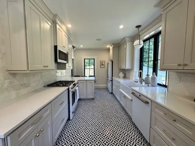 a large kitchen with stainless steel appliances granite countertop a lot of counter space and a sink