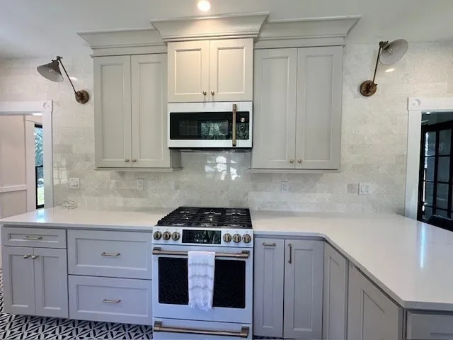 a kitchen with stainless steel appliances white cabinets and a stove top oven