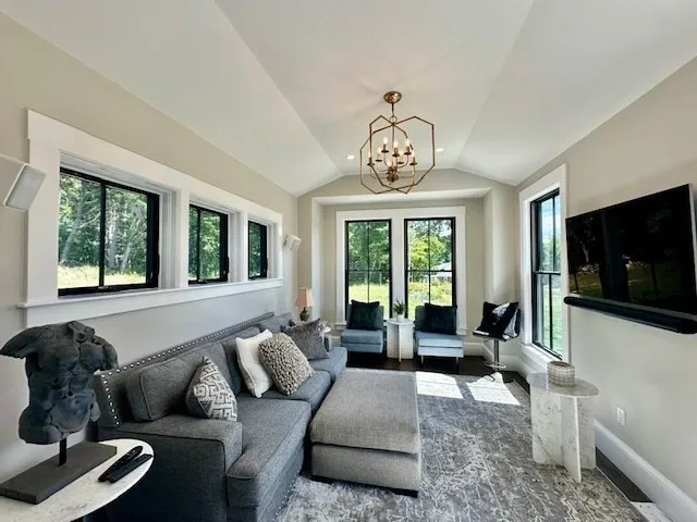 a living room with furniture potted plant and a large window