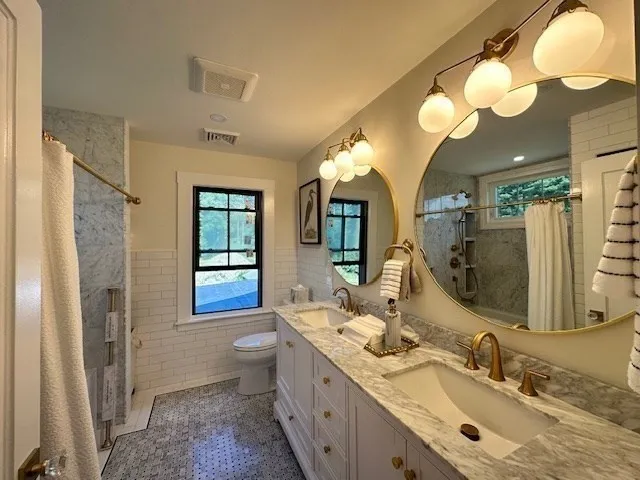 a bathroom with double vanity sink and a mirror
