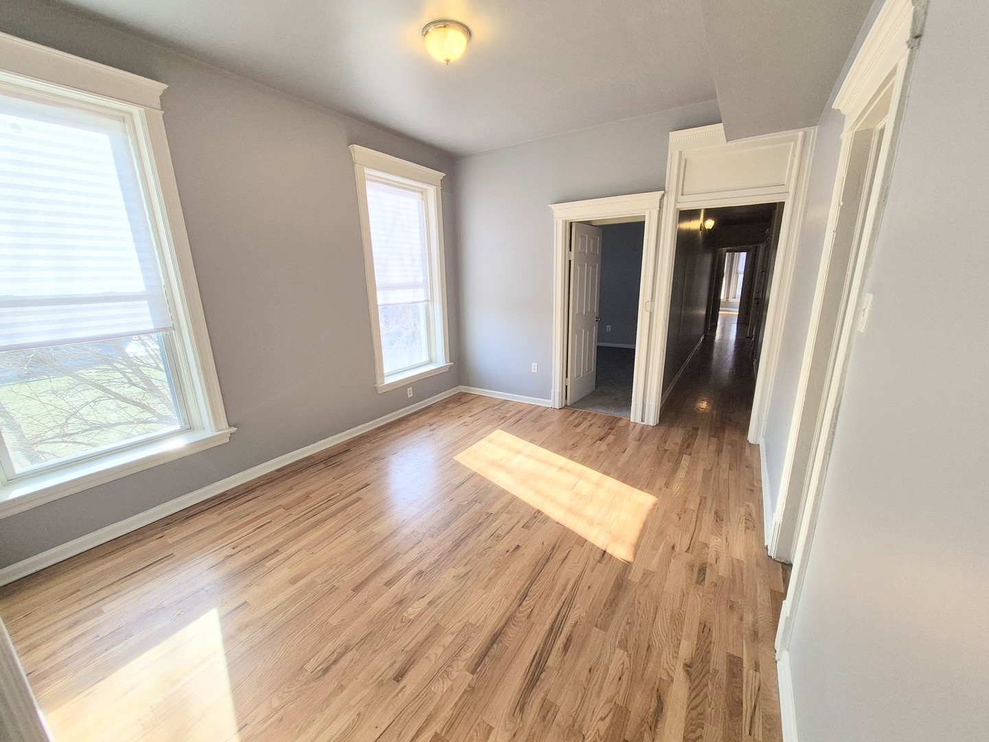 4243 South Calumet Avenue, Unit 2 Chicago, IL 60653 - Photo 5 of 8 a view of an empty room with wooden floor and a window