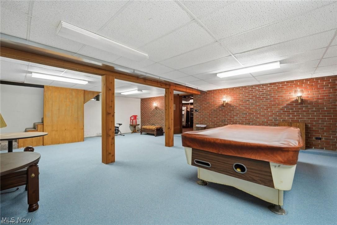 17452 Huntley Road Windsor, OH 44099 - Photo 41 of 49 Recreation room featuring a paneled ceiling, billiards, carpet flooring, and brick wall