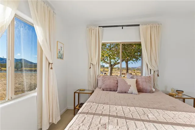 a bed sitting in a bedroom next to a window