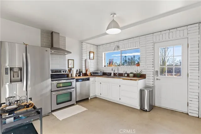a kitchen with granite countertop white cabinets and stainless steel appliances