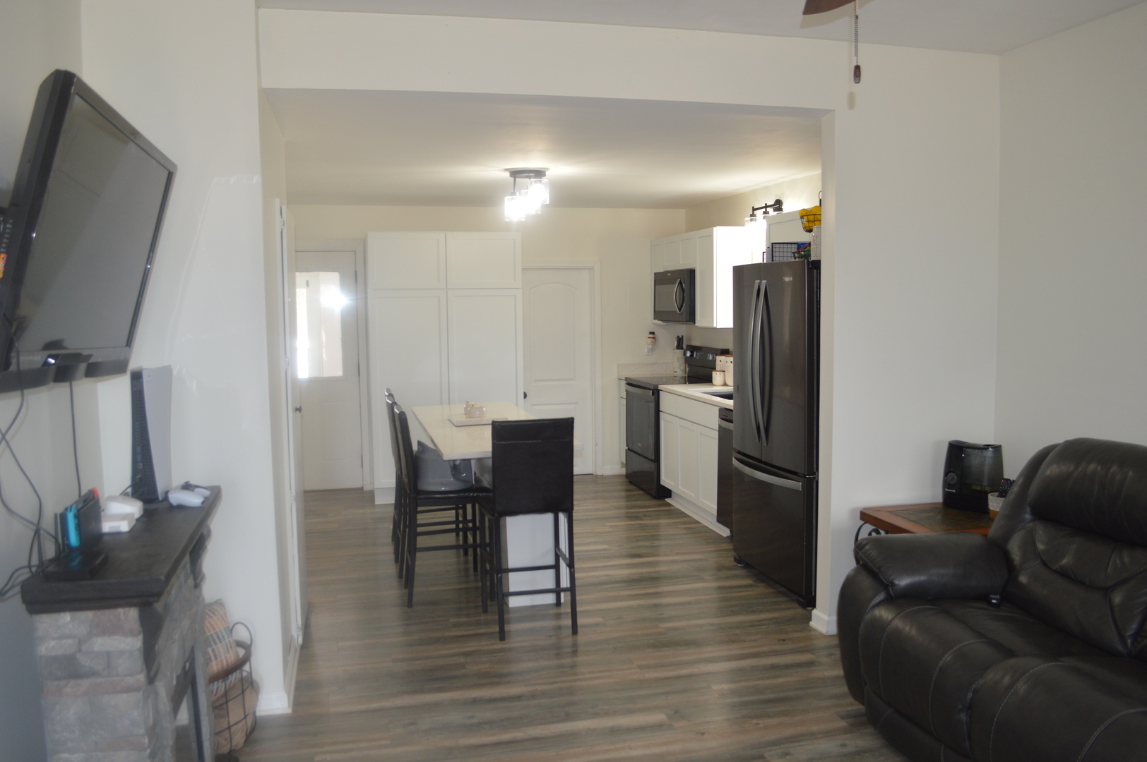 108 North Milwaukee Street Mark, IL 61340 - Photo 5 of 29 a kitchen with stainless steel appliances kitchen island granite countertop a refrigerator a stove a microwave oven a dining table and chairs with wooden floor
