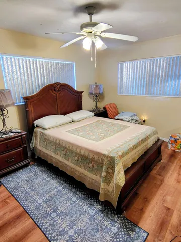 a bedroom with a bed dresser and a chandelier