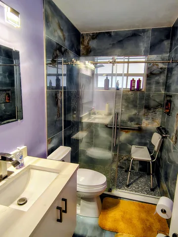 a bathroom with a sink mirror toilet and shower