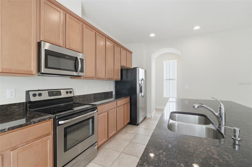 11486 Misty Oak Alley Windermere, FL 34786 - Photo 19 of 47 a kitchen with stainless steel appliances granite countertop a stove a microwave and a sink